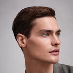 Gepflegter Mann mit kurz gestyltem braunem Haar und glatter Haut nach der Anwendung des GRAHAM HILL ARNAGE Face & Beard Balm.