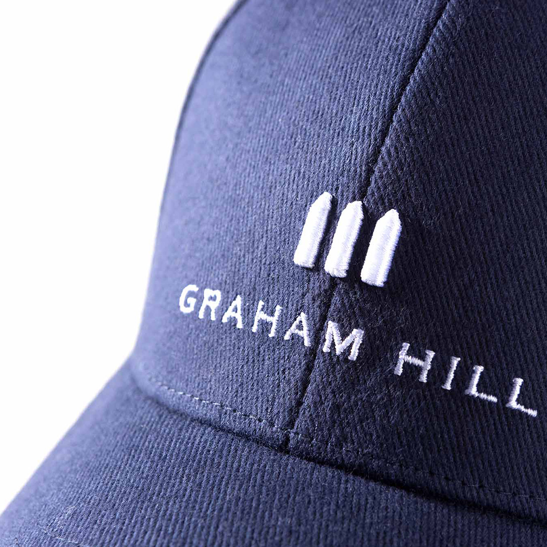 Detailansicht der dunkelblauen GRAHAM HILL Cap mit weißem, dreidimensional gesticktem Markenlogo